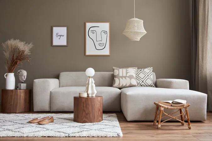 Salotto di una casa con pareti color tortora e arredamento dai toni crema e bianchi. Una delle tendenze colore 2024